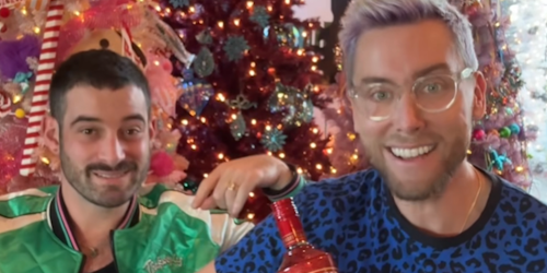 Lance Bass and his husband Michael Turchin in front of three Christmas trees