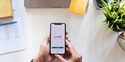 Man holding phone with LinkedIn logo on mobile screen