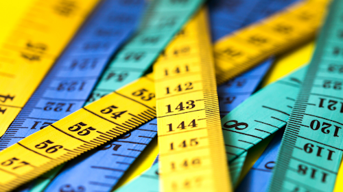 Measuring sticks in yellow, green and blue laid on top of each other