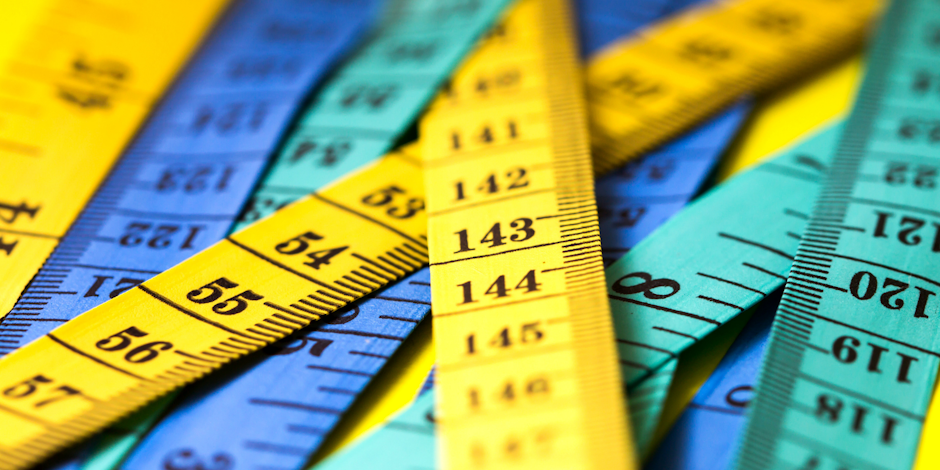 Measuring sticks in yellow, green and blue laid on top of each other
