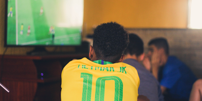 Guy watching soccer wearing a Neymar Jr jersey