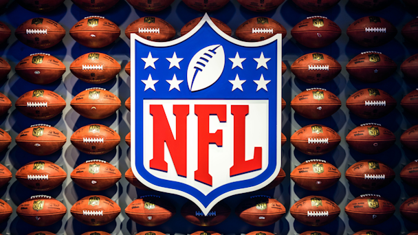 Footballs arranged on a wall around large NFL logo