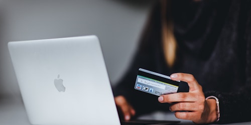 Person shopping on Macbook with credit card