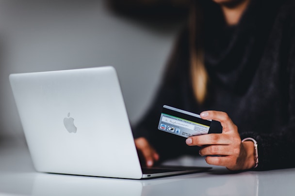 Person shopping on Macbook with credit card