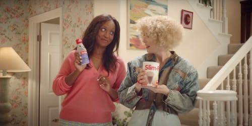 Two women holding different versions of SlimFast shakes Two women holding different versions of SlimFast shakes
