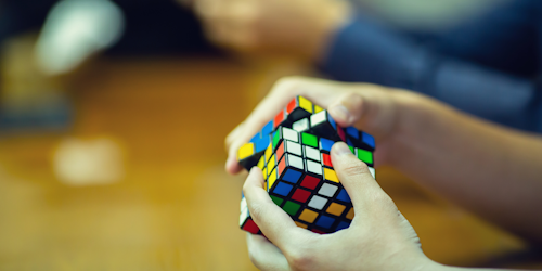 hands solving a Rubik's cube