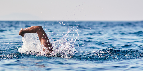 Man swimming through ocean water