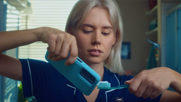 Woman using toothpaste from her phone