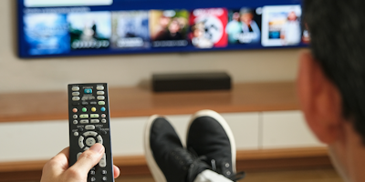 guy with remote control sitting in front of TV