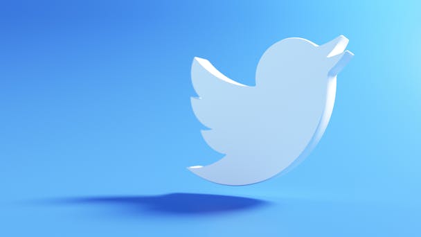 Twitter logo floating against blue background Twitter logo floating against blue background
