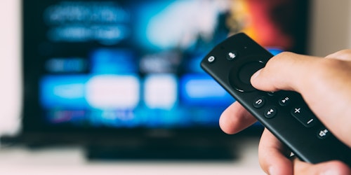 Man pointing a remote control at a TV
