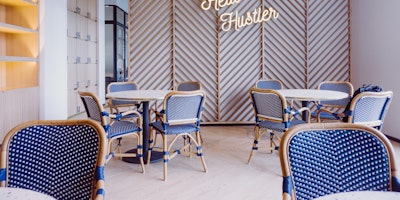 A painfully cool office environment, with a neon sign that reads "Hello Hustler"