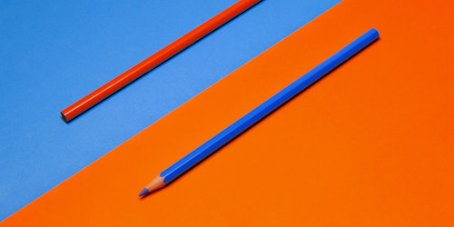 A red pencil on a blue background, and a blue pencil on a red background