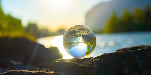 A clear marble reflecting the landscape such that it looks like a globe