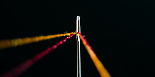 Lines of thread in the eye of a needle