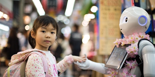 A young girl touching hands with a robot in a street