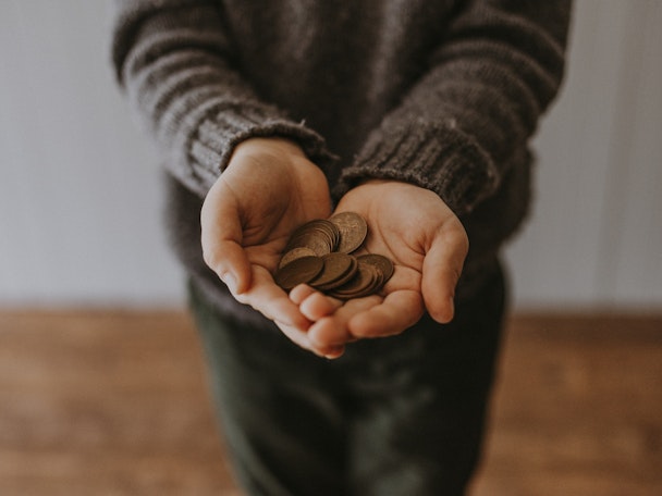 A person holding copper coins in their hands