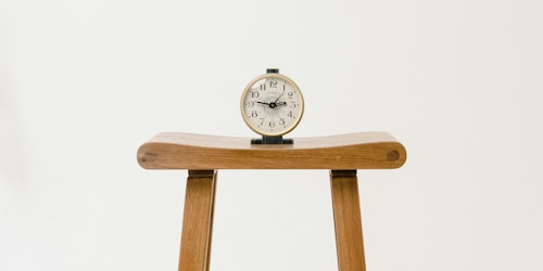 A clock, sat on a wooden stool