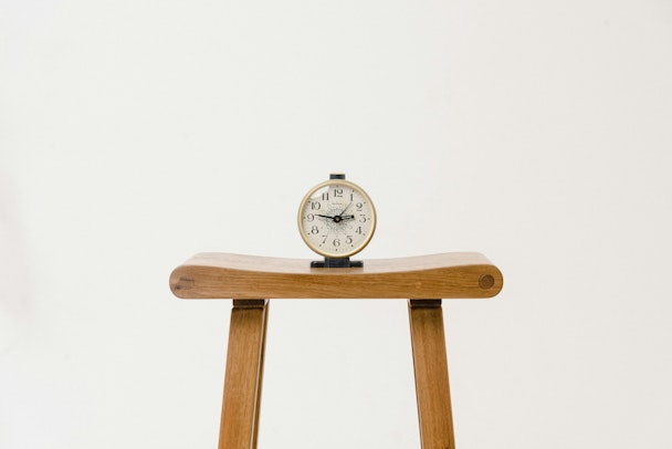 A clock, sat on a wooden stool