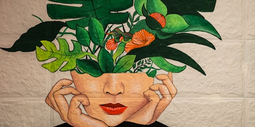 A vivid piece of graffiti, featuring a plant growing out of someone's head
