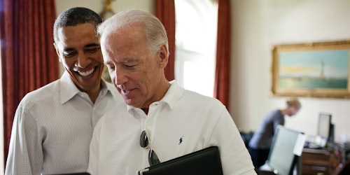 Presidents Joe Biden and Barack Obama looking at an iPhone