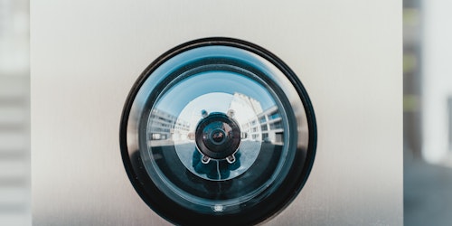 A surveillance camera set into a wall, up close