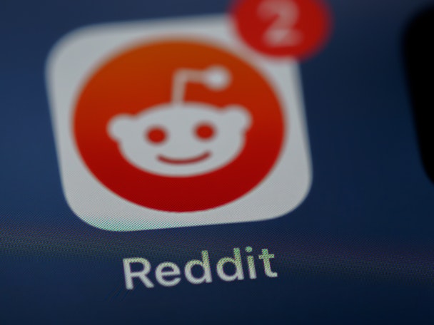 The Reddit logo, on a phone, blurred