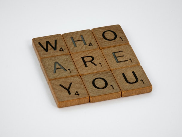 Scrabble tiles spelling out 'Who are you?'