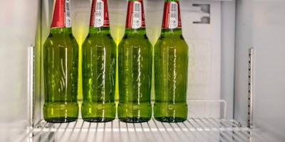 Green bottles of beer on a fridge shelf