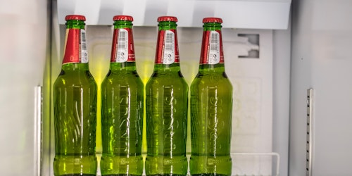 Green bottles of beer on a fridge shelf