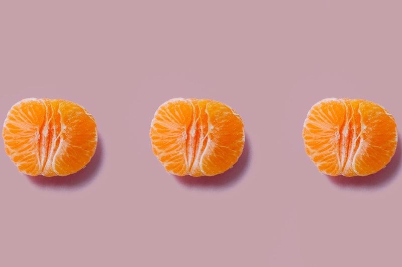 Three open halves of oranges on a purple background