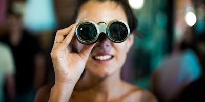 A woman looking through a pair of binoculars