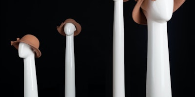 Four neck-and-hed mannequins with very long necks, wearing fancy brown hats