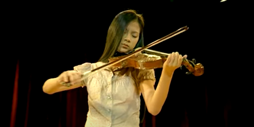 A still from Pantene's 'Chrysalis' TV spot: a girl playing a violin