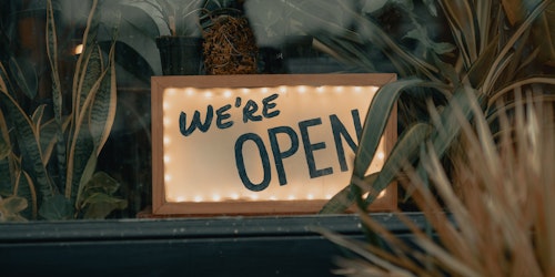 A sign in a shop window saying "we're open"