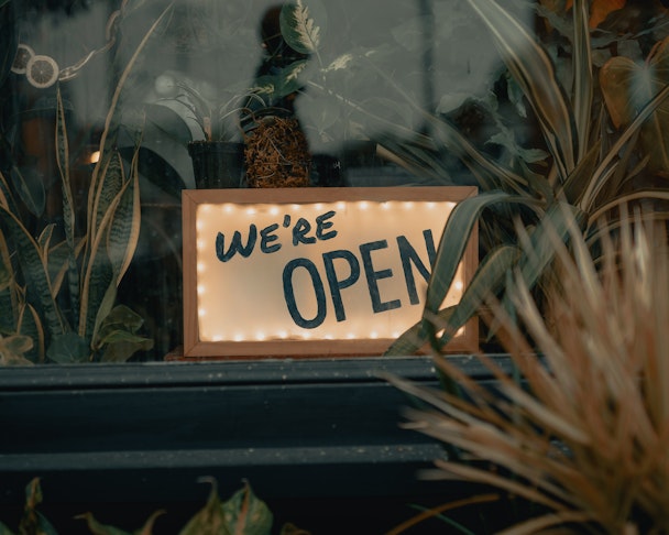 A sign in a shop window saying "we're open"
