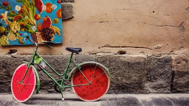 A customized bicycle, made to look like a watermelon, in a colorful setting