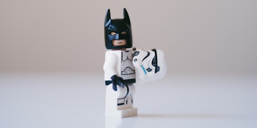A storm trooper Lego figure, having revealed their helmet to reveal Batman's cowl