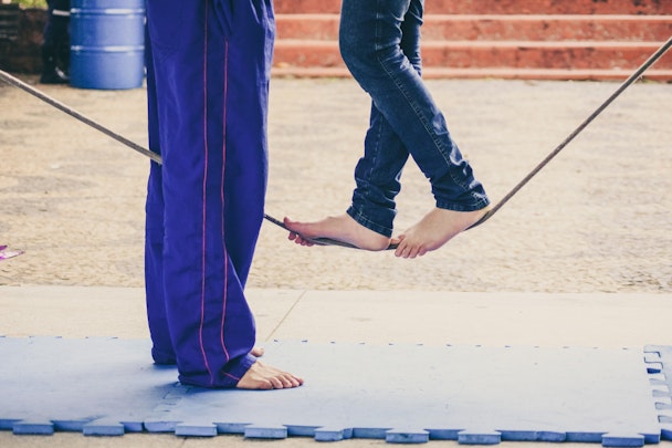 A pair of feet walking along a tightrope