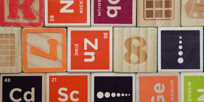 A stack of colorful wooden blocks depicting elements from the periodic table