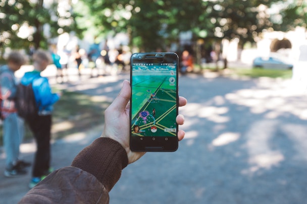 A phone playing Pokemon Go in a park