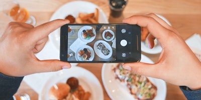 A phone taking a picture of a lavish meal