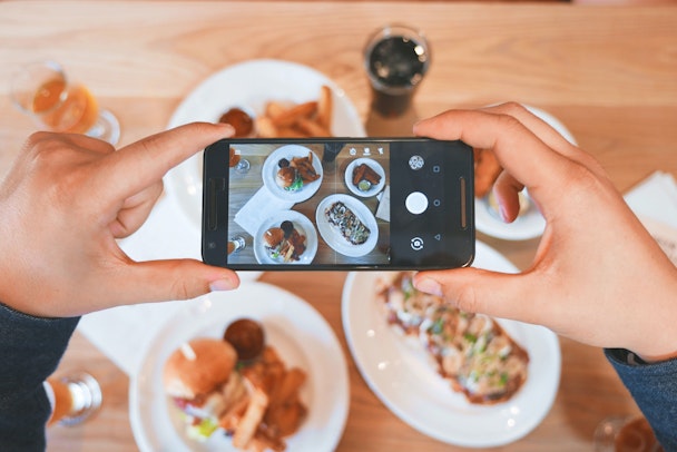 A phone taking a picture of a lavish meal