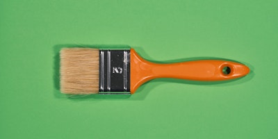 A paintbrush on a green background