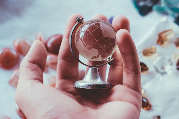 A tiny glass globe, held in the palm of a hand