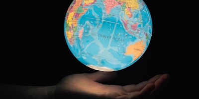 A globe floating above the palm of a hand