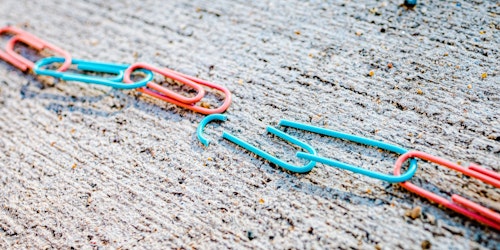 A broken chain of colored paperclips