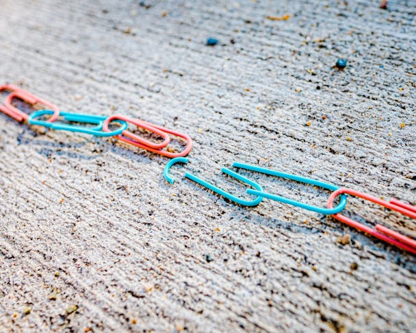 A broken chain of colored paperclips A broken chain of colored paperclips