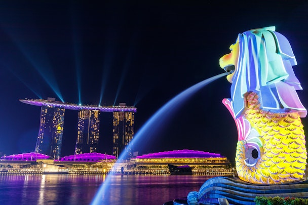 A neon-lit nighttime view of Singapore's iconic marina