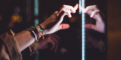 A hand, reaching out to touch a digital screen
